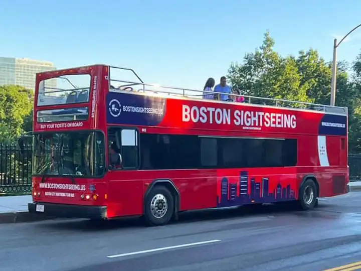 A red Boston Sightseeing open-top double-decker bus